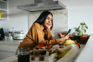 Woman staying consistent with her New Years resolution by tracking her nutrition using the Cronometer app.